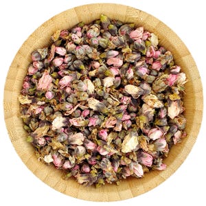 May include: A wooden bowl filled with dried peach blossoms. The blossoms are a mix of pink and white, and some are still closed while others are open.