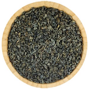 May include: A close-up of a wooden bowl filled with loose leaf green tea. The tea leaves are dark green and have a slightly curled shape.