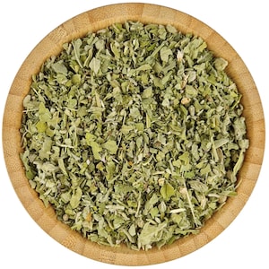 May include: A wooden bowl filled with dried green herbs. The herbs are finely chopped and have a light green color.