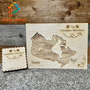 Puede incluir: Un mapa de madera de Canadá con las provincias y territorios delineados. El mapa está sin terminar y tiene espacios para nombres y fechas. El texto "Mis aventuras canadienses" está escrito en la parte superior del mapa. El mapa está sobre un fondo de madera.