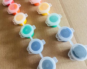 May include: A set of 10 paint pots with lids, arranged in two rows. The paint colors are red, orange, yellow, green, blue, and black.