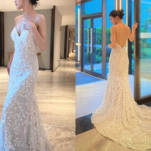 Op de afbeelding: Een witte bruidsjurk met een strakke buste en een zwierige rok. De jurk is versierd met delicate bloemenborduursels en een lage rug.