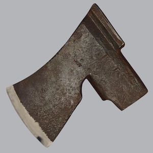 May include: A dark brown, weathered metal axe head featuring a wide, curved cutting edge with a bright, polished silver finish. The main body of the axe head displays a textured, oxidized surface with visible markings and a rectangular poll.