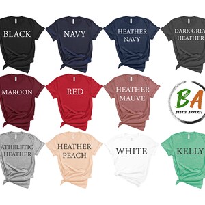 Puede incluir: Una colecci&oacute;n de diez camisetas de diferentes colores, incluyendo negro, azul marino, azul jaspeado, gris jaspeado oscuro, granate, rojo, malva jaspeado, gris jaspeado atl&eacute;tico, melocot&oacute;n jaspeado, blanco y verde kelly. Cada camiseta tiene un color diferente y est&aacute; etiquetada con el nombre del color.