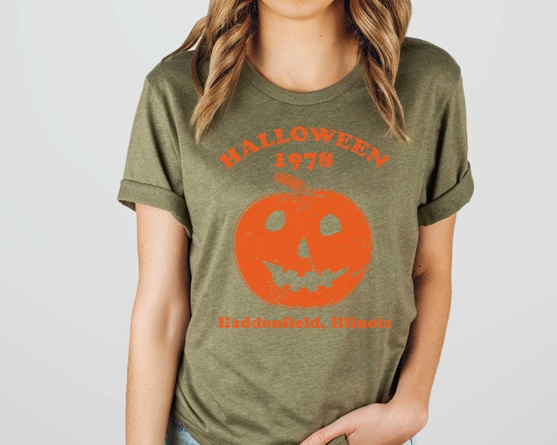 May include: A green t-shirt with an orange pumpkin graphic and the text "Halloween 1978 Haddonfield, Illinois".