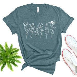 May include: A teal blue t-shirt with a white outline of a row of flowers on the front.