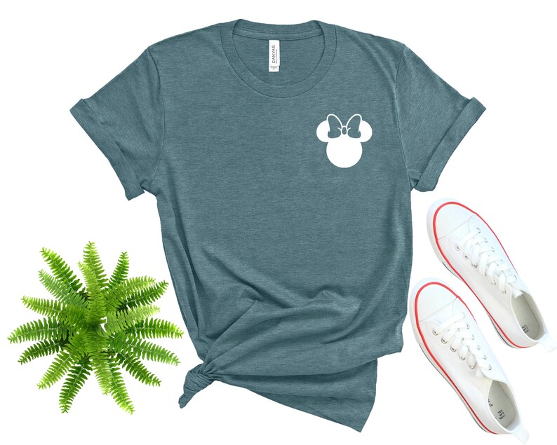 May include: A teal blue t-shirt with a white silhouette of Minnie Mouse's head with a bow on top.