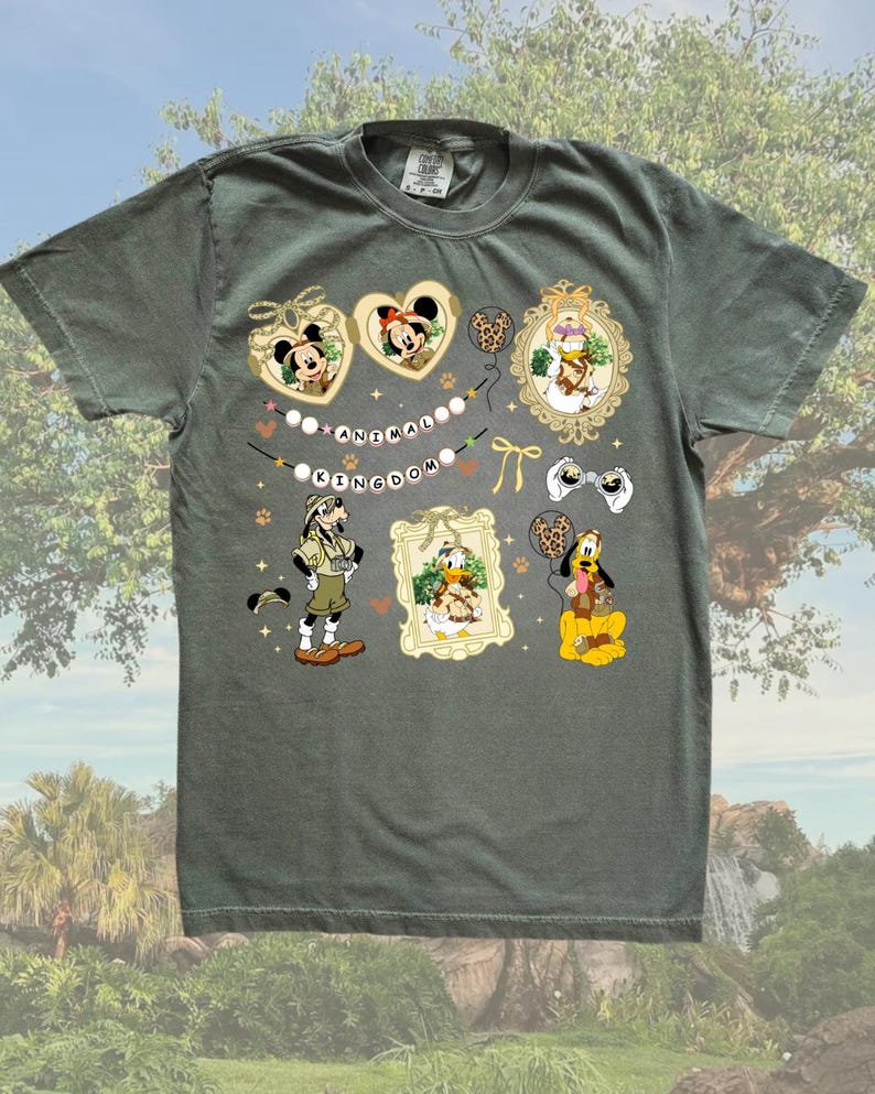May include: A green t-shirt with a print of various Disney characters from Animal Kingdom. The characters include Mickey Mouse, Minnie Mouse, Donald Duck, Goofy, and Pluto. The print also includes the words "Animal Kingdom" in a banner.