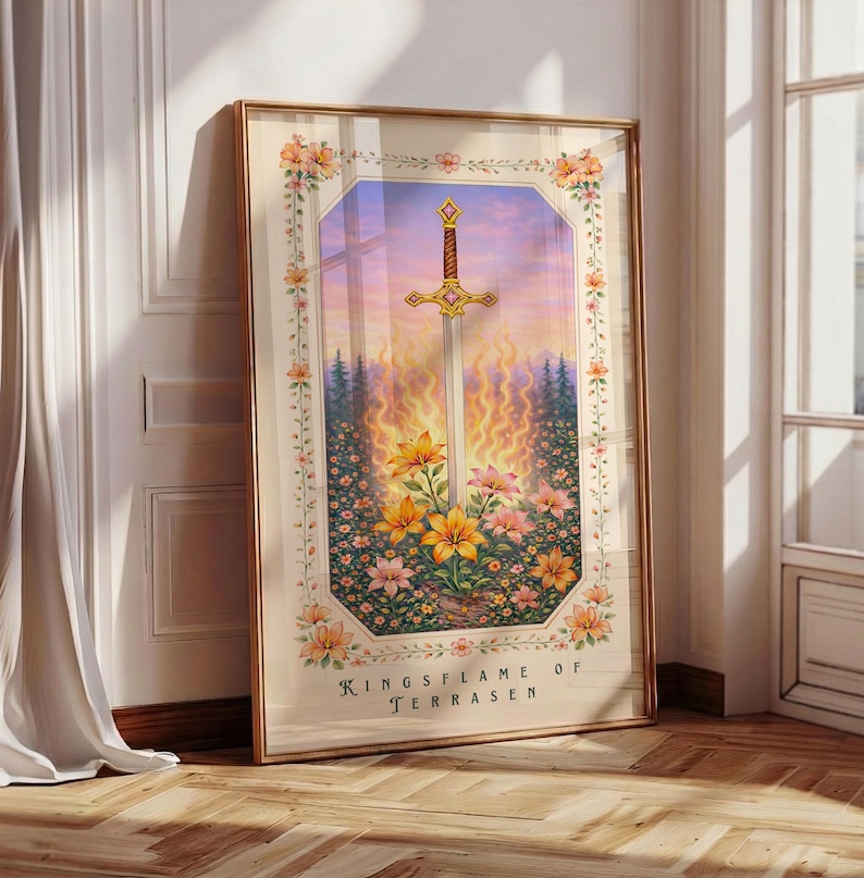 May include: Framed art print featuring a sword with a gold hilt, set against a backdrop of flames, flowers, and a sunset sky. The artwork is surrounded by a floral border and includes the text "Kingsflame of Terrasen."