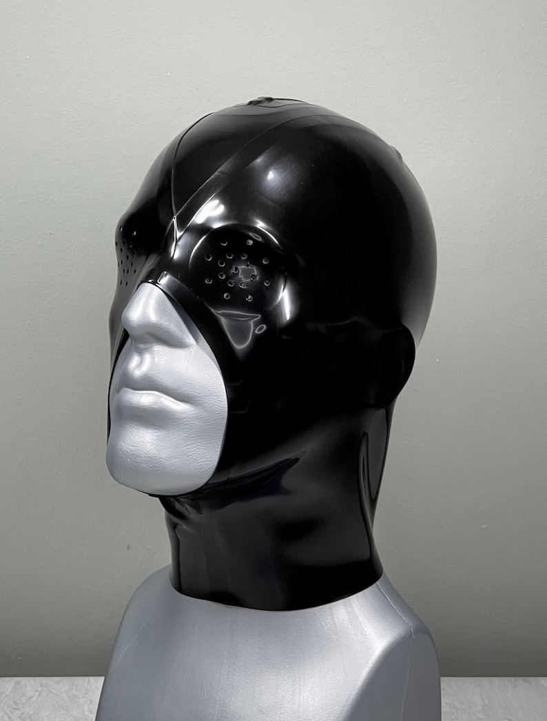 May include: A black latex mask with a single eye hole and a small, round, black opening on the side. The mask covers the head and neck.