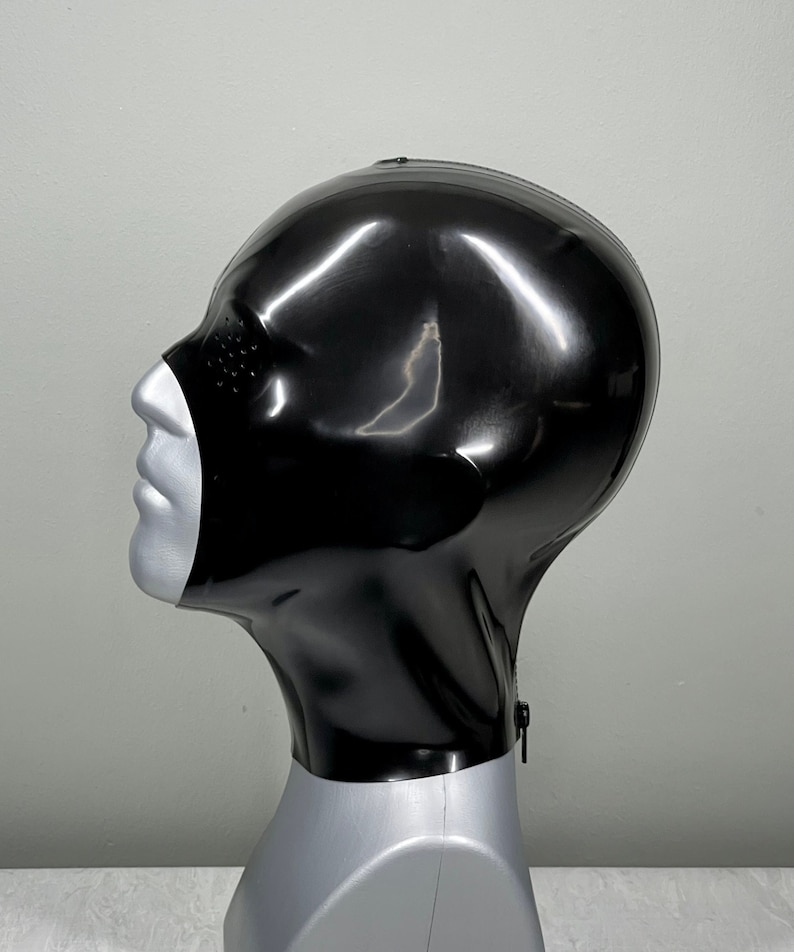 May include: A black latex hood with a zipper closure and eye holes. The hood is displayed on a mannequin head.