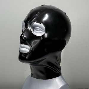 May include: A black latex mask with white eye and mouth openings. The mask is shiny and has a smooth texture.