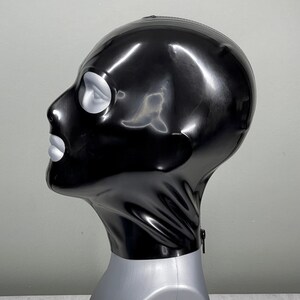 May include: A black latex balaclava with a zipper closure and a single eye hole.