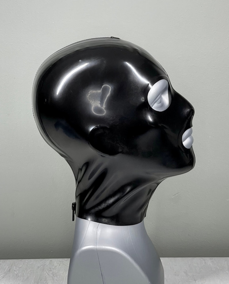 May include: A black latex hood with a silver eye hole and mouth opening. The hood is on a gray mannequin head.