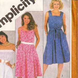 May include: Vintage Simplicity sewing pattern featuring three dress designs. The pattern includes a white off-the-shoulder dress, a pink floral print dress, and a blue dress with a square neckline. The text "OVERNIGHT SUCCESS" is also visible.