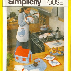 May include: A Simplicity House sewing pattern envelope for 10 kitchen items, featuring a white apron, oven mitts, a tea cosy shaped like a house, a chicken-shaped placemat, and square pot holders, all decorated with blue gingham chicken motifs.