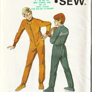 May include: Vintage Kwik Sew pattern 858 featuring illustrations of two children in jumpsuits. The pattern includes the text "Ages: 10-12-14" and the Kwik Sew logo. The jumpsuit on the left is orange, and the one on the right is teal.