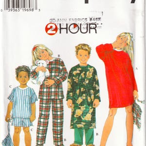May include: Simplicity sewing pattern 7407, size BB 5, 6, 7, 8. The envelope features illustrations of children wearing pajamas, a robe, and a nightgown. Text includes 2 HOUR, Jo-Ann Fabrics, and sewing time only/temps de couture seulement.