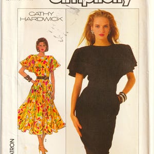 Peut inclure: Patron de couture Simplicity avec deux modèles de robes. L'une est une robe noire mi-longue avec une manche à volants. L'autre est une robe mi-longue avec un imprimé abstrait coloré. Taille 12.