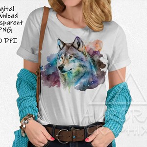 Pode incluir: Uma camiseta branca com um design de aquarela de uma cabeça de lobo com um fundo de galáxia.