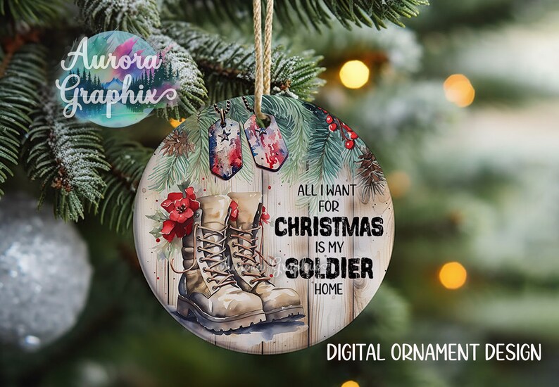 May include: A round Christmas ornament with a watercolor design of a pair of brown military boots, pine branches, red berries, and two dog tags. The text "All I want for Christmas is my soldier home" is written on the ornament.