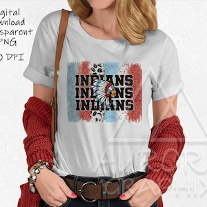 Könnte beinhalten: Ein weißes T-Shirt mit einem rot-weiß-blauen Grafikdesign, das das Wort "INDIANS" dreimal wiederholt. Die Grafik enthält auch eine indianische Kopfbedeckung mit Federn.