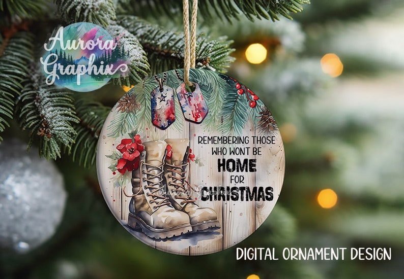 May include: A round, wooden Christmas ornament with a watercolor design. It features a pair of brown military boots, a red poinsettia, and two dog tags with the American flag. The text reads "Remembering those who won't be home for Christmas".
