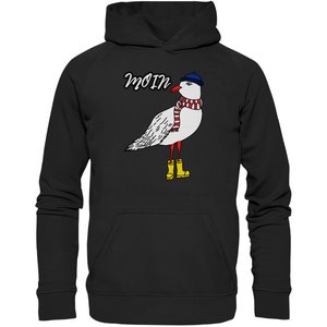 May include: Black hoodie with a white seagull wearing a blue hat, red and white scarf, and yellow rain boots. The text "Moin" is printed above the seagull.