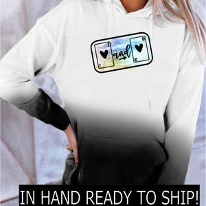 May include: White ombre hoodie with a black graphic of two playing cards, a 2 of hearts and a 10 of hearts, with the word "and" and an arrow between them.