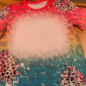 May include: A short-sleeved shirt with a colorful ombre design featuring a leopard print pattern. The shirt has a crew neck and is made of a soft, comfortable fabric.