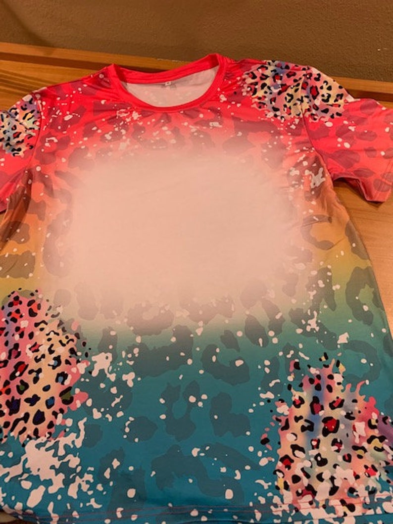 May include: A short-sleeved shirt with a colorful ombre design featuring a leopard print pattern. The shirt has a crew neck and is made of a soft, comfortable fabric.