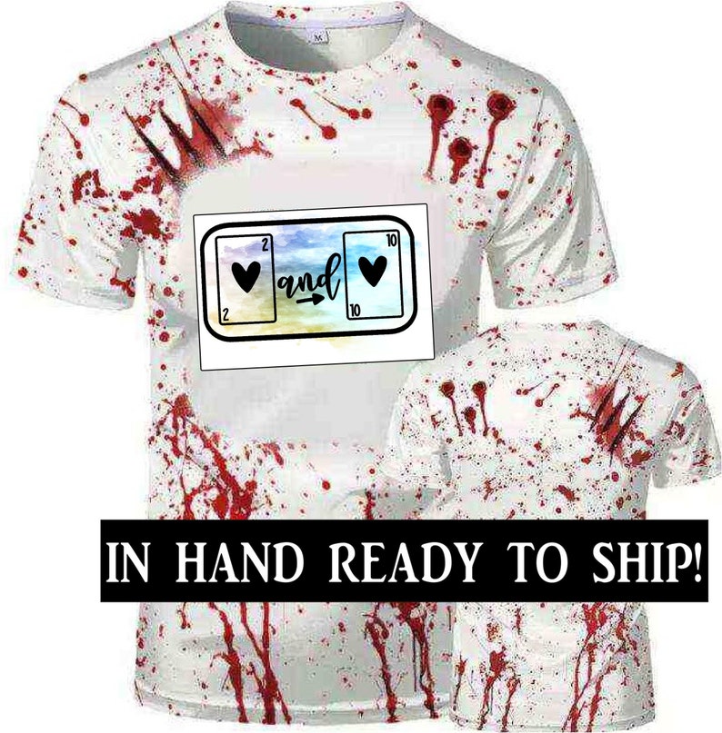 May include: White t-shirt with red blood splatter and a graphic of two playing cards with hearts and the word "and" between them.