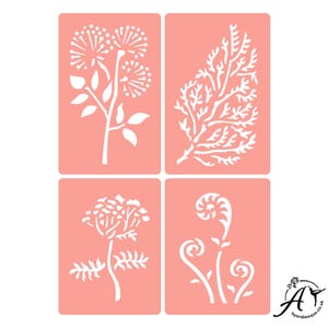 May include: Set of four floral stencils, each featuring a different design. The stencils are white and cut out on a pink background. The designs include a cluster of flowers, a fern, a branch with leaves, and a cluster of flowers with leaves.