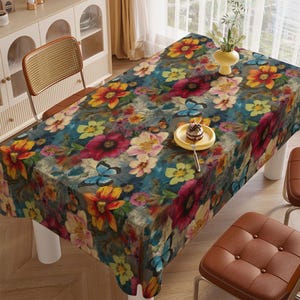 Pode incluir: Uma toalha de mesa retangular com um padrão floral e de borboletas. O design apresenta um fundo azul escuro com flores coloridas em tons de vermelho, amarelo e rosa, e borboletas azuis. A toalha de mesa está sobre uma mesa branca.