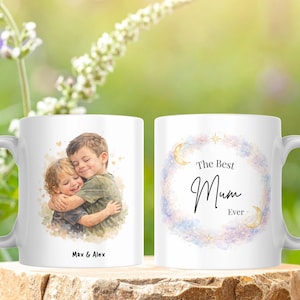 May include: White ceramic mug featuring a watercolor illustration of two children hugging, with the text "Max & Alex" below. The other side has the text "The Best Mum Ever" inside a floral wreath.