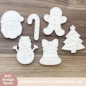 以下が含まれることがあります： 未完成の木製クリスマスをテーマにした切り抜きコレクション。サンタの顔、キャンディケイン、ジンジャーブレッドマン、雪だるま、リボン付きのベル、クリスマスツリーが含まれています。木製の表面に配置されています。