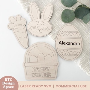 May include: Four unfinished wooden Easter craft shapes: a bunny, a carrot, a basket with eggs, and an egg with the text "Alexandra".