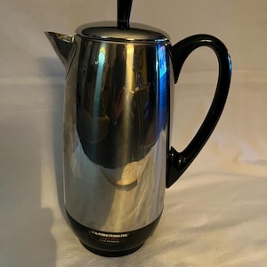 以下が含まれることがあります： 黒いハンドルと蓋のノブが付いた、ステンレス製のFarberware Superfastコーヒーパーコレーター。電気コーヒーポットは黒いベースと注ぎ口が付いています。ブランド名は前面に印刷されています。