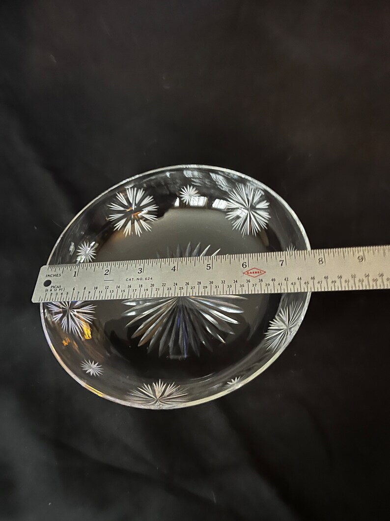 May include: A clear glass dish with a starburst pattern. The dish is approximately 7 inches in diameter.