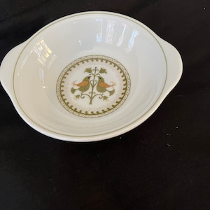 May include: White ceramic bowl with two green birds on a tree branch in the centre. The bowl has a green and gold border with a scalloped edge. The bowl has two handles on the sides.