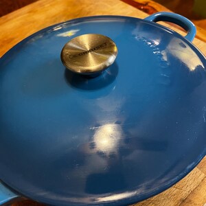 May include: A blue enamelled cast iron pot with a silver knob and the text "Le Creuset" on the lid.
