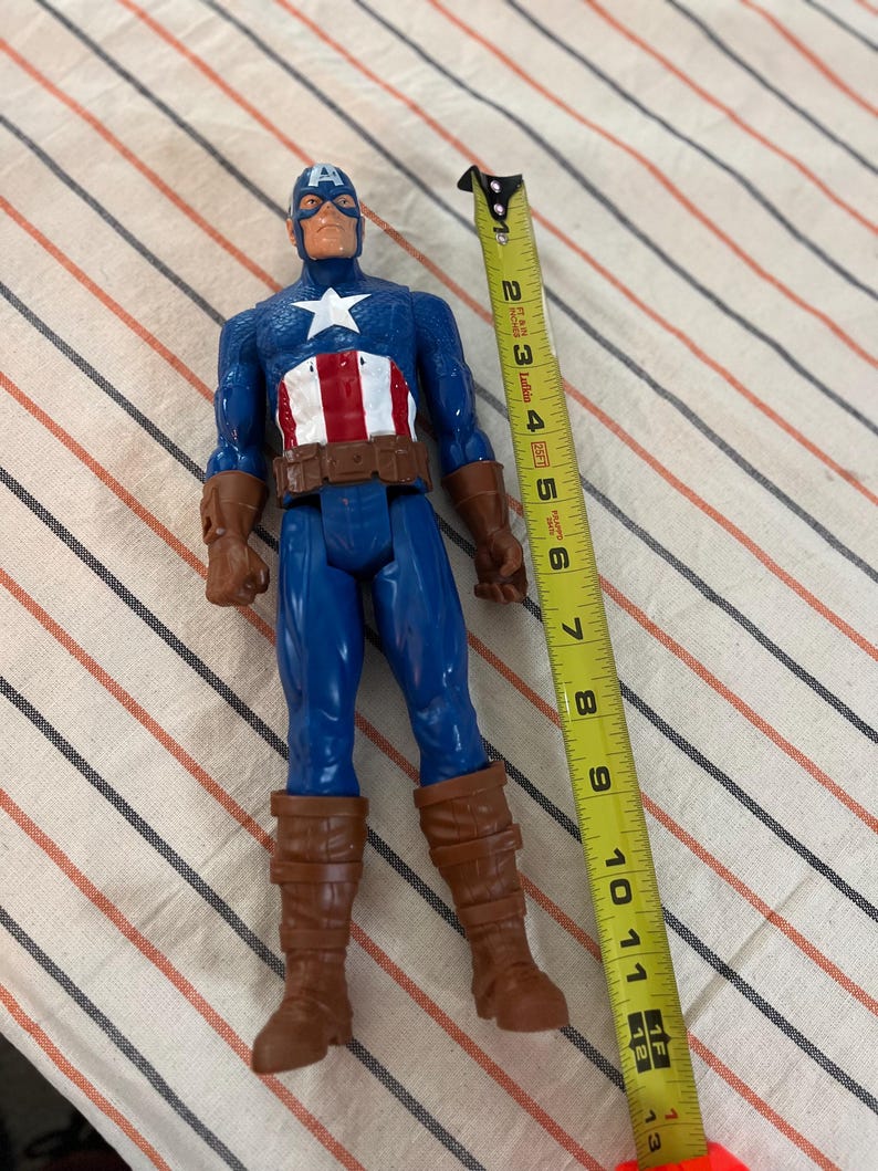 May include: A blue and red Captain America action figure with a brown belt and boots. The figure is 11 inches tall.