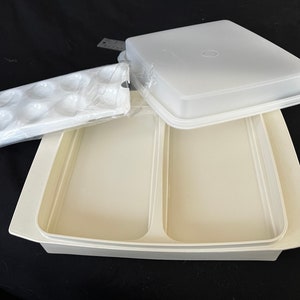 May include: White plastic container with a lid and a removable tray with 12 compartments. The container is divided into two sections.