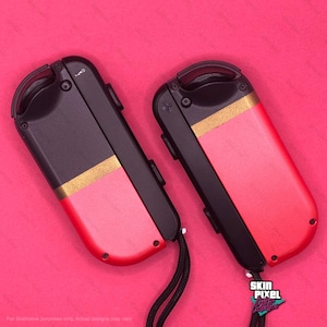 Peut inclure: Deux manettes Nintendo Switch Joy-Con noires et rouges avec des accents dorés. Les manettes sont sur un fond rose. Skin Pixel Custom Controllers.