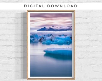 May include: A photograph of a glacial lagoon in Iceland with blue icebergs floating in the water. The sky is a vibrant purple and pink with clouds.