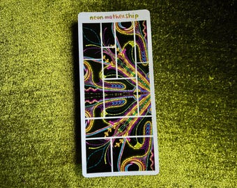 May include: A rectangular sticker with a black background and a colorful, abstract design. The design features neon pink, yellow, blue, and purple swirls and lines. The text "neon mothership" is at the top.