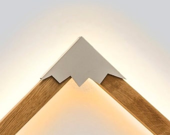 May include: A wooden lamp shaped like a mountain with a white peak. The lamp is lit and casts a warm glow.