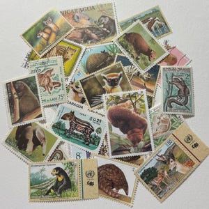 May include: A collection of colorful postage stamps featuring various animals, including a tapir, lemur, and deer. The stamps are from different countries and include text such as "Endangered Species" and "United Nations".