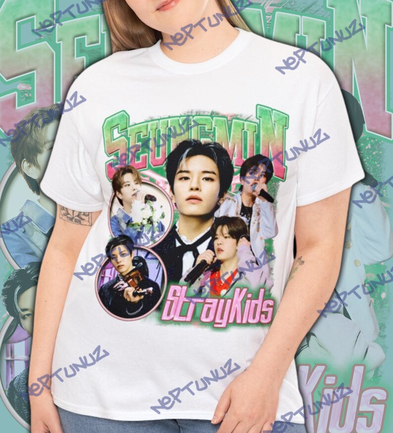 Puede incluir: Camiseta blanca con un gr&aacute;fico de la banda Stray Kids. El dise&ntilde;o presenta el texto "Seungmin" en verde y rosa, y m&uacute;ltiples im&aacute;genes de los miembros de la banda en un estilo vintage.