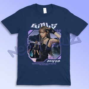 Puede incluir: Camiseta azul marino con un gr&aacute;fico de una mujer, el texto "GIRLS" y "AESPA". El dise&ntilde;o incluye un marco geom&eacute;trico p&uacute;rpura con la palabra "WINTER". La camiseta est&aacute; hecha de un material suave y c&oacute;modo.